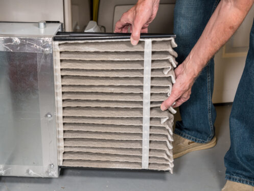 A man changing a filter in a furnace in Phoenix, AZ