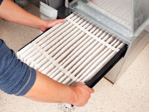 A homeowner changing the furnace filter in Peoria, AZ